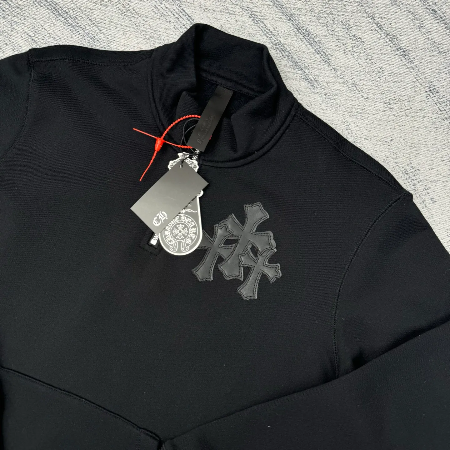 P406 Chrome Heart FW25 leather cross half-zip sweatshirt Size: S/M/L/XL Made of high-weight pure cotton terry fabric Pre-shrunk to ensure wearing stability Three-dimensional leather cross label Half-zip neckline with dagger-shaped zipper pull Combined with curved hem tailoring and kangaroo pocket